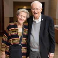 Man and woman standing together, smiling at camera